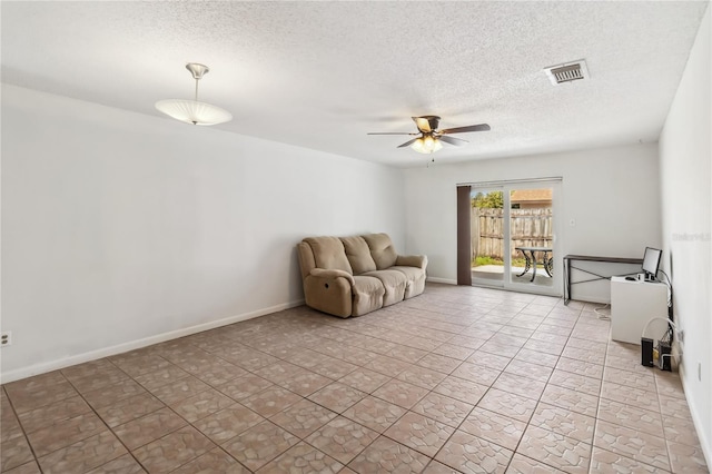 unfurnished living room with visible vents, ceiling fan, a textured ceiling, and baseboards