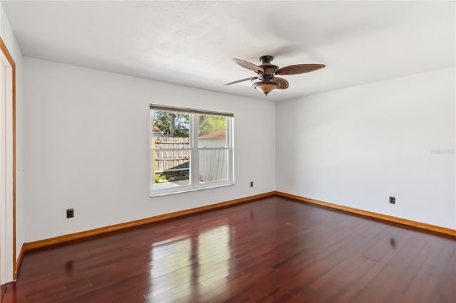 empty room with a ceiling fan, baseboards, and wood finished floors