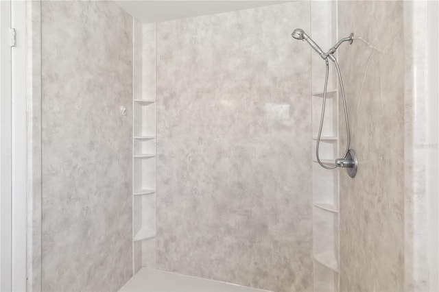 interior details with a tile shower