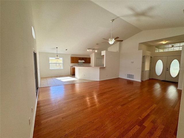 unfurnished living room featuring high vaulted ceiling, visible vents, ceiling fan, and wood finished floors