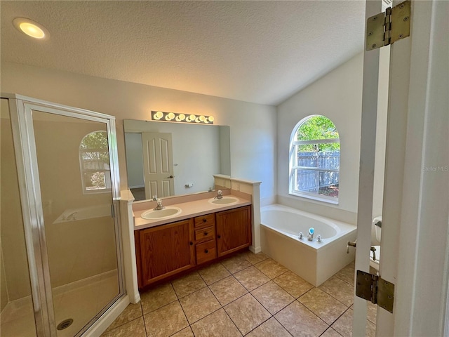 full bathroom featuring a stall shower, a garden tub, a sink, and a textured ceiling