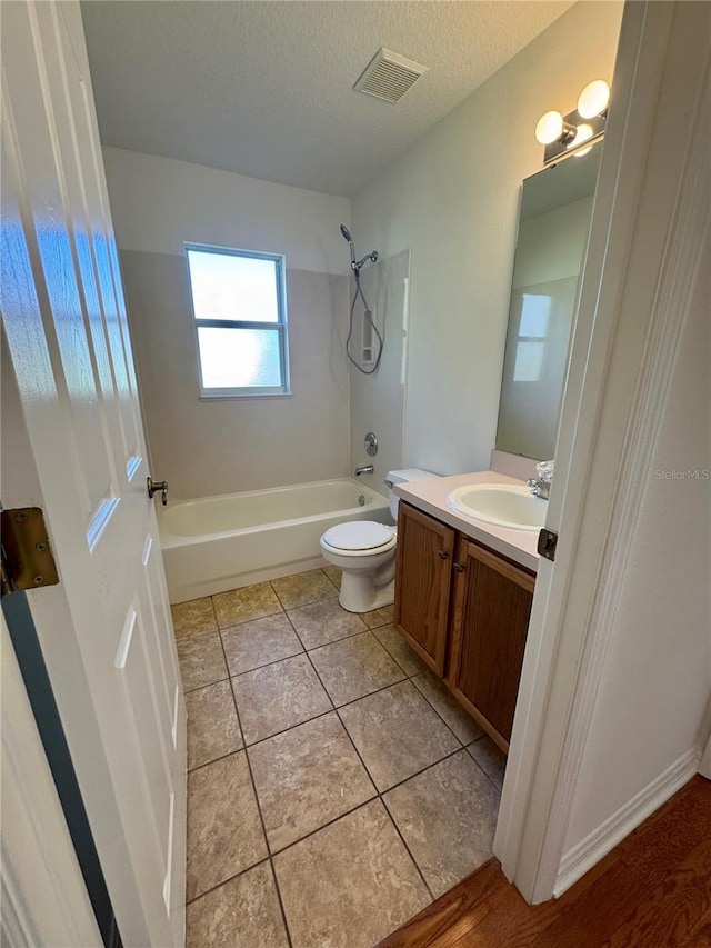 full bathroom with visible vents, tile patterned floors, a textured ceiling, vanity, and shower / bathing tub combination