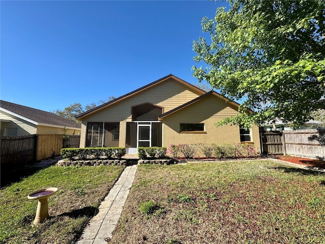 view of front of home with a front lawn, fence, and a sunroom