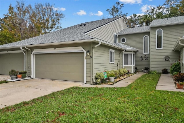 view of front facade with a garage, a front yard, driveway, and a shingled roof