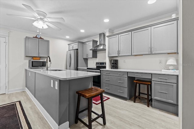 kitchen with wall chimney exhaust hood, appliances with stainless steel finishes, and gray cabinets