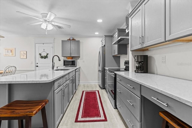 kitchen with appliances with stainless steel finishes, a sink, and gray cabinetry