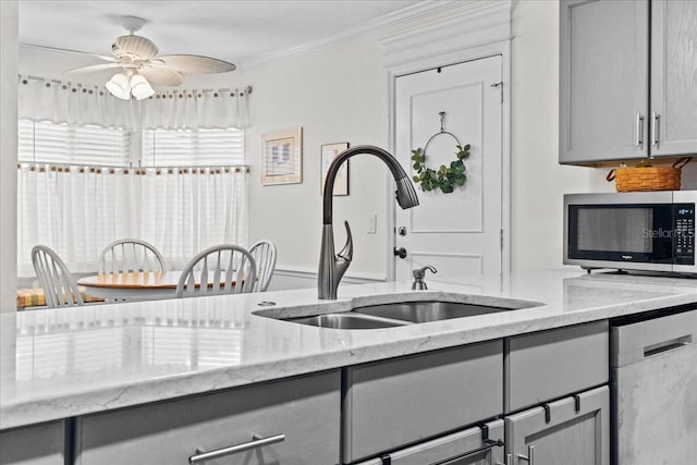 kitchen featuring ornamental molding, appliances with stainless steel finishes, gray cabinets, and a sink