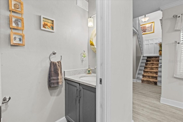 bathroom featuring baseboards, wood finished floors, and vanity