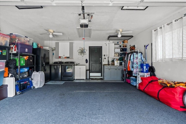 garage featuring ceiling fan, separate washer and dryer, black fridge, and a garage door opener