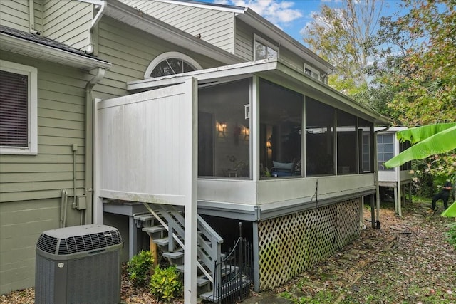 view of home's exterior with a sunroom and central AC