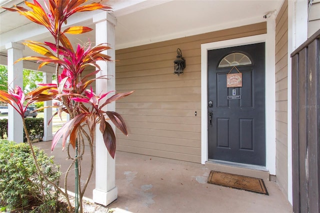 view of exterior entry featuring covered porch