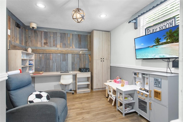 office featuring built in desk, wood finished floors, and recessed lighting