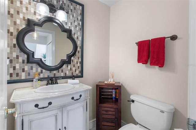 bathroom with toilet, tasteful backsplash, and vanity