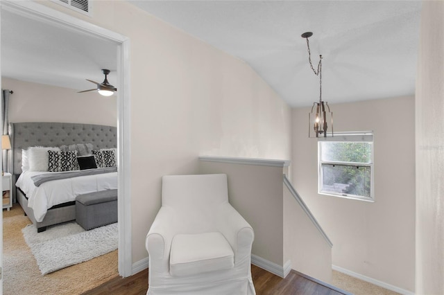 bedroom with visible vents, baseboards, wood finished floors, vaulted ceiling, and a notable chandelier