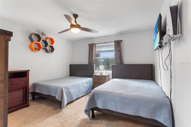 bedroom featuring light carpet, ceiling fan, and a textured ceiling