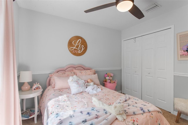 carpeted bedroom with a closet, visible vents, and a ceiling fan