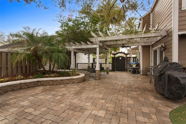 view of patio with a gate, fence, area for grilling, and a pergola