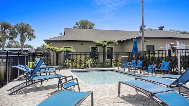 community pool with a patio and fence