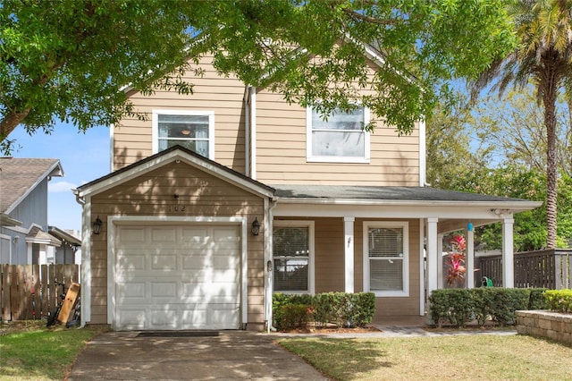 traditional home featuring a front lawn, fence, driveway, and an attached garage