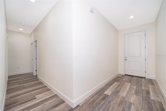 hall featuring light wood-style flooring and baseboards