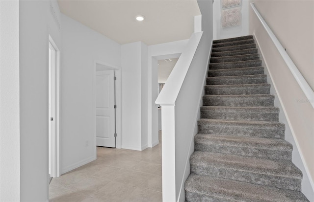 stairs with tile patterned flooring and recessed lighting