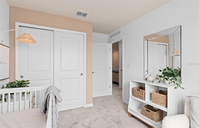 bedroom featuring baseboards, visible vents, a closet, and light colored carpet