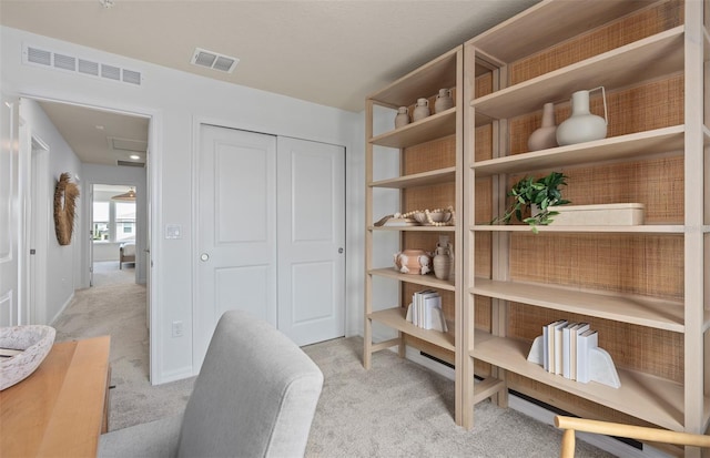 interior space featuring light carpet, visible vents, and baseboards