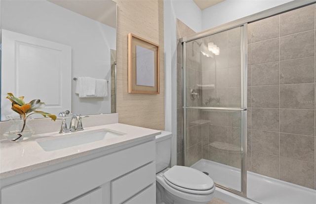 full bathroom featuring a shower stall, toilet, and vanity