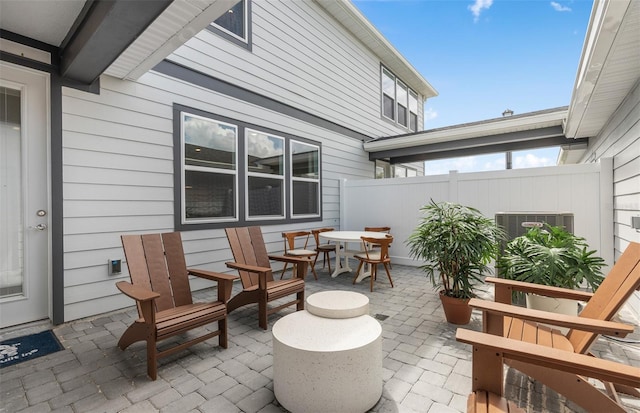 view of patio with outdoor dining space, cooling unit, and fence