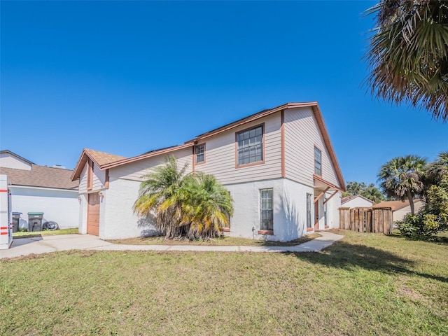 view of front of home with a garage, fence, driveway, stucco siding, and a front lawn