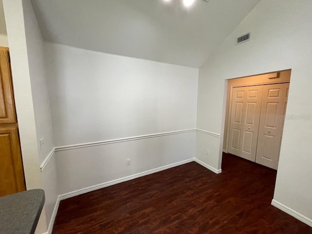 unfurnished room with visible vents, wood finished floors, baseboards, and vaulted ceiling