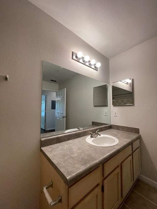 bathroom featuring tile patterned flooring, vanity, and baseboards