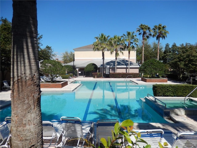 community pool with a patio area and a community hot tub