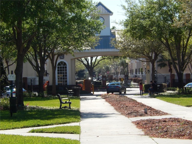 view of community with a lawn and fence