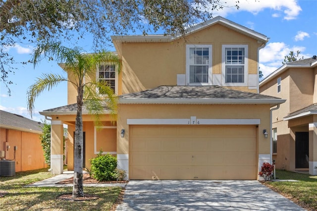 traditional-style house featuring roof with shingles, driveway, and stucco siding