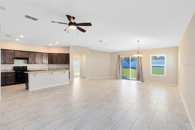 kitchen with visible vents, ceiling fan with notable chandelier, black electric range, open floor plan, and dark brown cabinetry