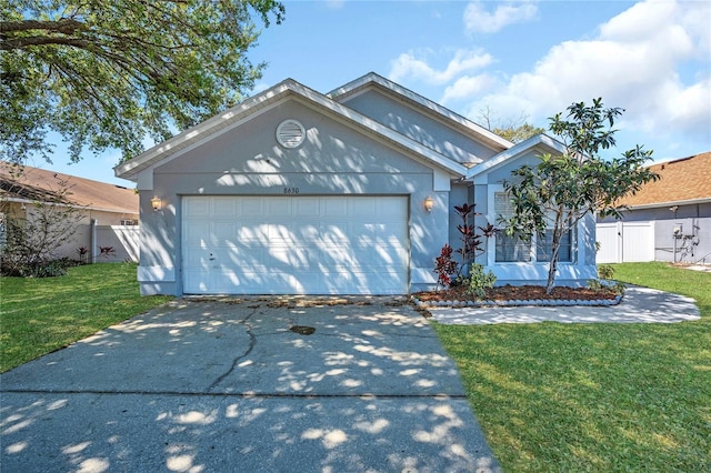 ranch-style home featuring a garage, driveway, a front lawn, and fence