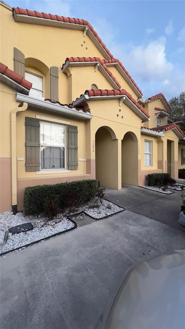 mediterranean / spanish house with a tiled roof and stucco siding