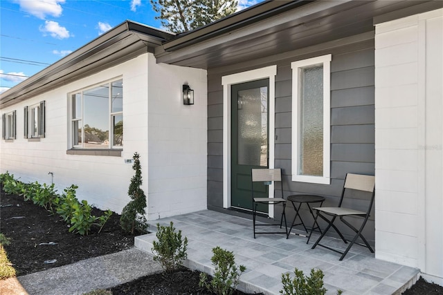 doorway to property with a patio area and concrete block siding