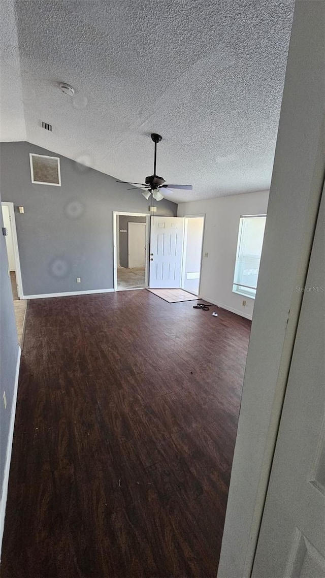 unfurnished living room with visible vents, ceiling fan, a textured ceiling, wood finished floors, and baseboards