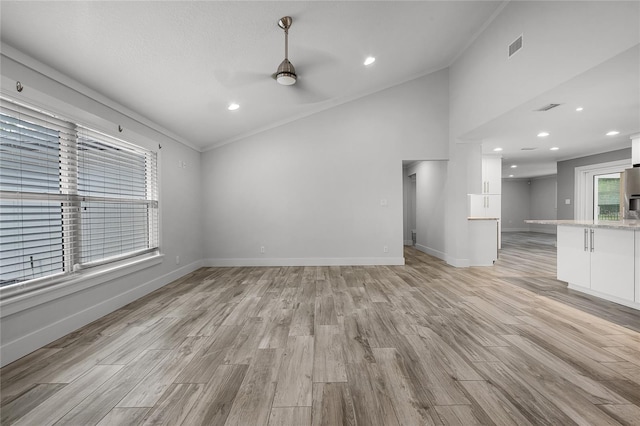 unfurnished living room featuring light wood finished floors, visible vents, ceiling fan, and baseboards