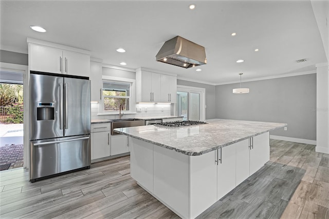 kitchen featuring visible vents, range hood, stainless steel appliances, white cabinetry, and a sink