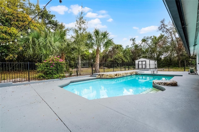 view of swimming pool with a patio, fence, a fenced in pool, and a shed