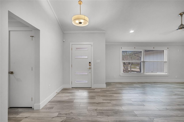 foyer entrance featuring light wood-type flooring, baseboards, and ornamental molding