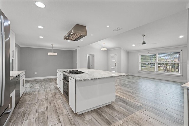 kitchen with a center island, wood finish floors, ornamental molding, stainless steel appliances, and white cabinetry