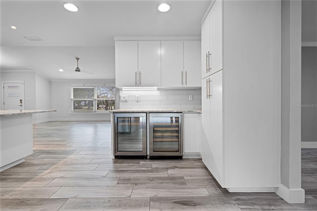 kitchen with wine cooler, recessed lighting, white cabinetry, and wood tiled floor