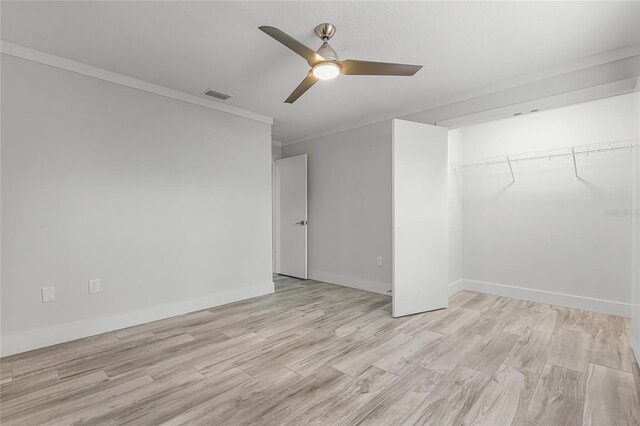 empty room with light wood finished floors, visible vents, crown molding, baseboards, and ceiling fan