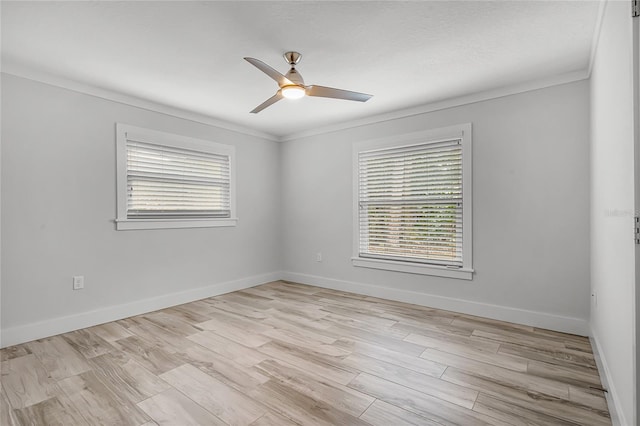 spare room with baseboards, light wood-style floors, ceiling fan, and ornamental molding