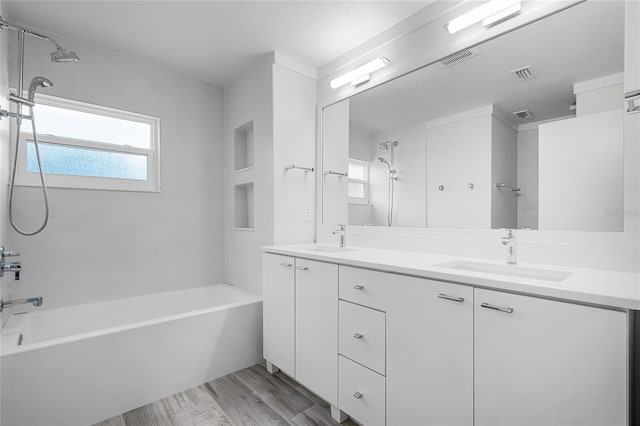 bathroom with double vanity, visible vents, wood finished floors, and a sink