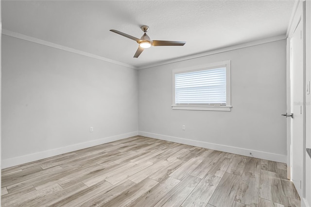 spare room with a ceiling fan, baseboards, ornamental molding, light wood-style floors, and a textured ceiling